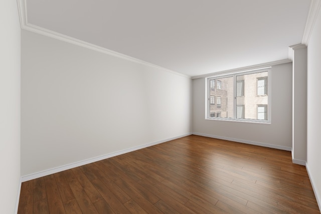 empty room featuring baseboards, dark wood-style flooring, and crown molding