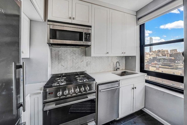 kitchen featuring light countertops, appliances with stainless steel finishes, a sink, and tasteful backsplash