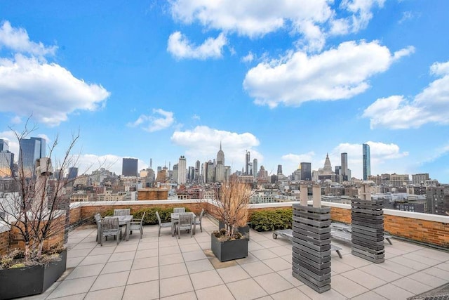 view of patio with outdoor dining space and a view of city