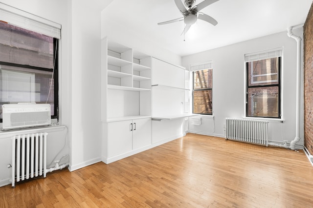 unfurnished room featuring light wood-style flooring, radiator heating unit, and ceiling fan