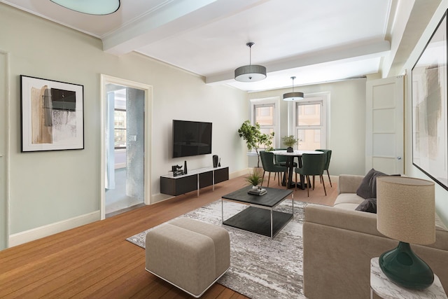living area featuring beamed ceiling, baseboards, and wood finished floors