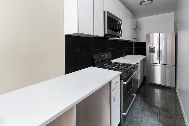 kitchen with white cabinets, stainless steel appliances, light countertops, granite finish floor, and modern cabinets