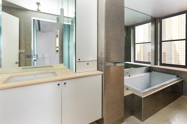 bathroom featuring tile patterned floors, a garden tub, and vanity