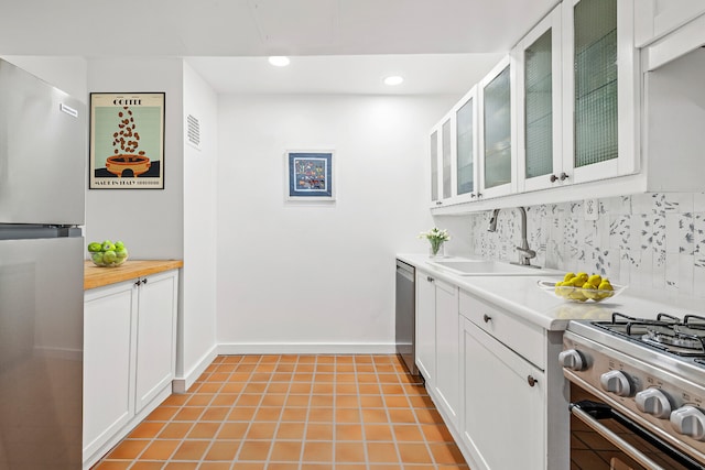 kitchen with visible vents, a sink, decorative backsplash, stainless steel appliances, and white cabinetry