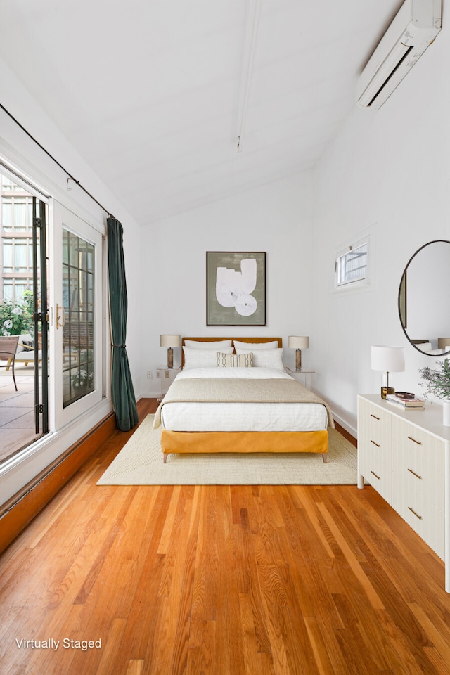 unfurnished bedroom featuring multiple windows, lofted ceiling, an AC wall unit, and wood finished floors