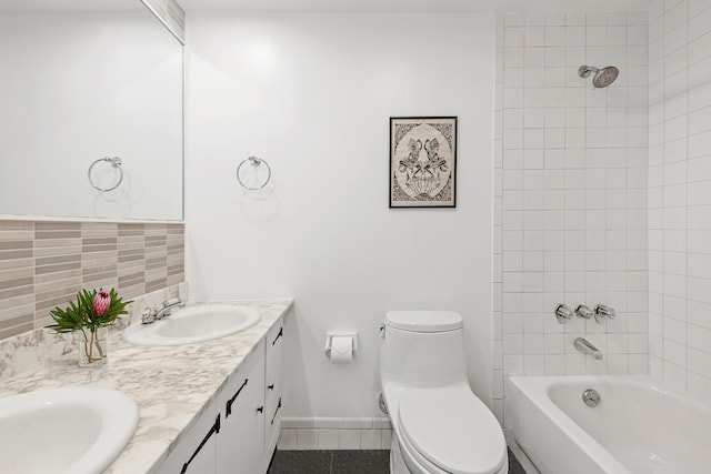 bathroom featuring tile patterned floors, toilet, a sink, double vanity, and shower / bath combination