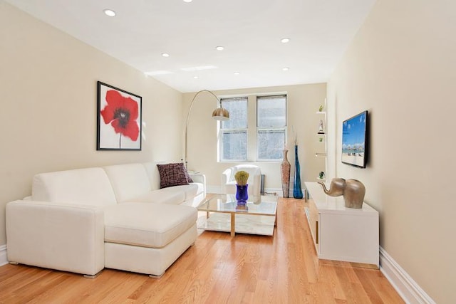 living room with recessed lighting, baseboards, and light wood finished floors