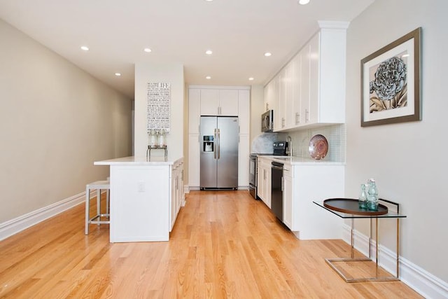775 Riverside Dr Unit 3D, New York City, NY 10032 - kitchen with light countertops, tasteful backsplash, a breakfast bar, a peninsula, and stainless steel appliances