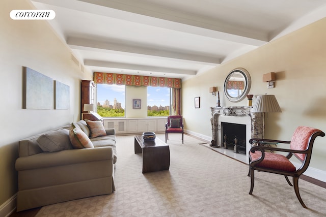 living area featuring a high end fireplace, beam ceiling, baseboards, and visible vents