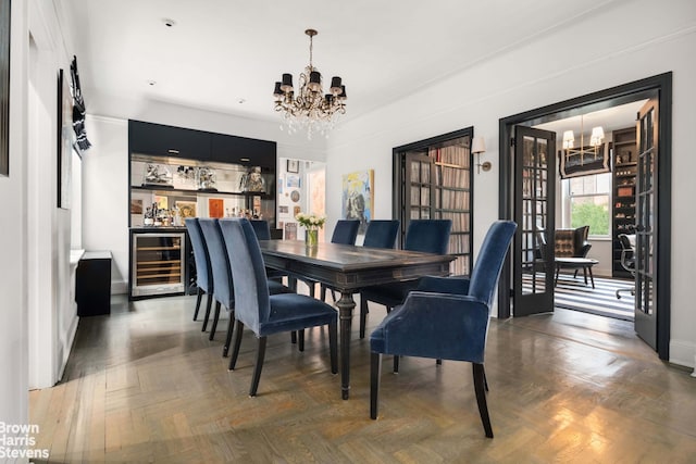 dining space featuring a chandelier, wine cooler, and a dry bar