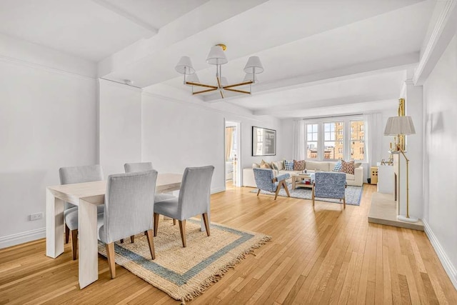 dining area with light wood-type flooring, baseboards, beamed ceiling, and a chandelier