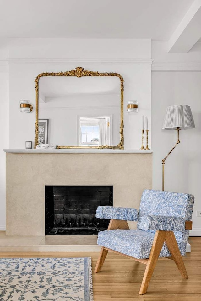 sitting room featuring a high end fireplace and wood finished floors