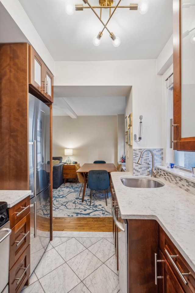 kitchen with backsplash, open floor plan, appliances with stainless steel finishes, marble finish floor, and a sink