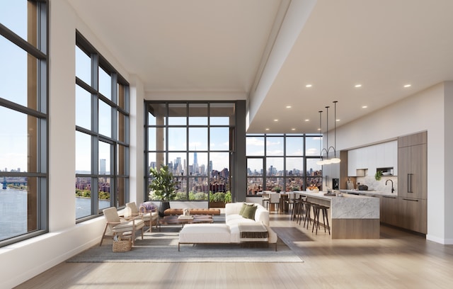 interior space featuring a city view, baseboards, a towering ceiling, and wood finished floors