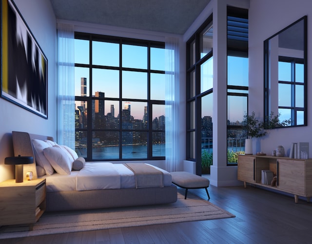 bedroom with hardwood / wood-style floors and a view of city