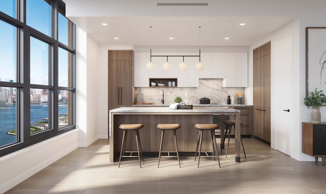 kitchen with backsplash, modern cabinets, light countertops, and white cabinetry