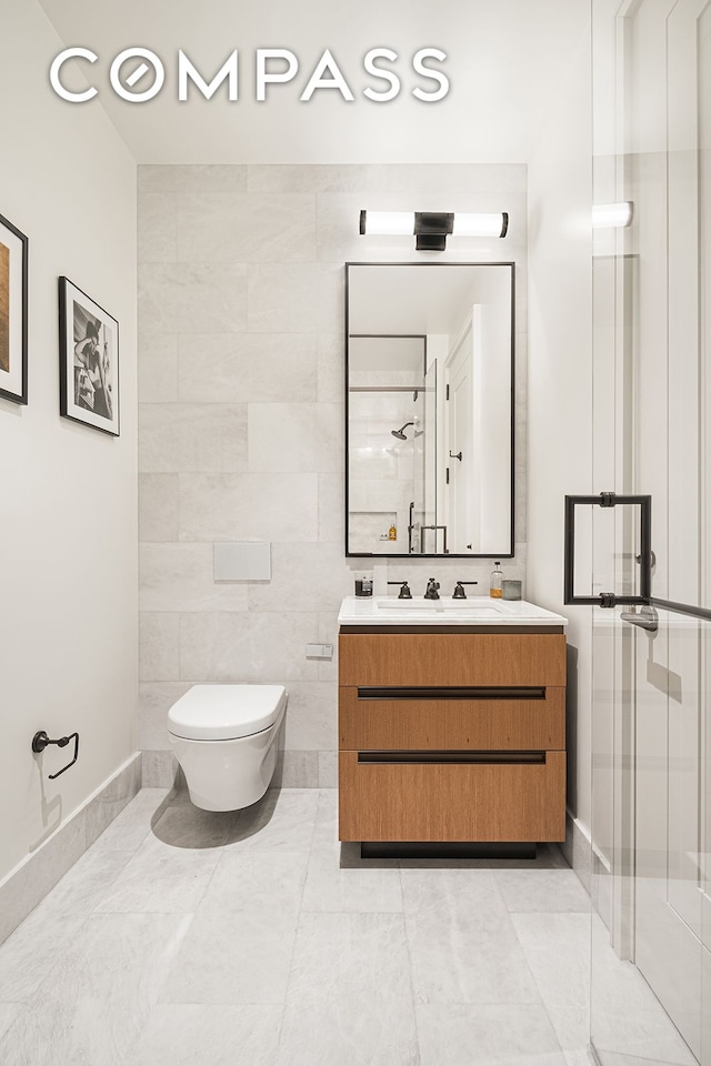 bathroom with vanity, tile walls, toilet, and a stall shower