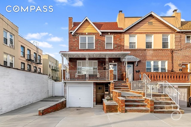 multi unit property with concrete driveway, an attached garage, and brick siding