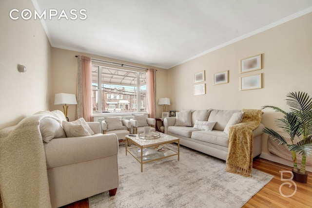 living area featuring baseboards, wood finished floors, and crown molding