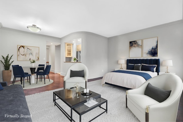 bedroom with wood finished floors, baseboards, stainless steel fridge, and ornamental molding