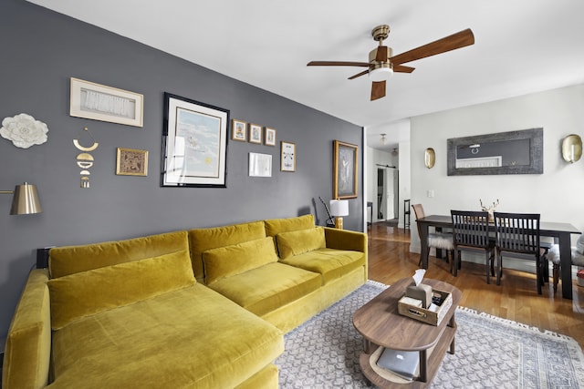 living area with ceiling fan and wood finished floors