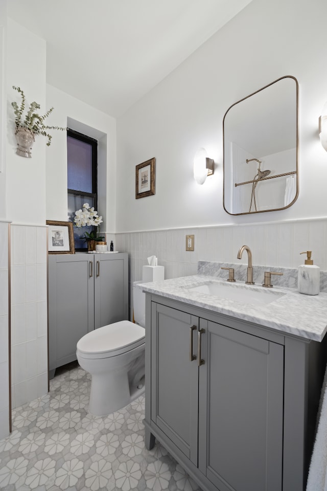 full bathroom with vanity, toilet, a shower, and wainscoting