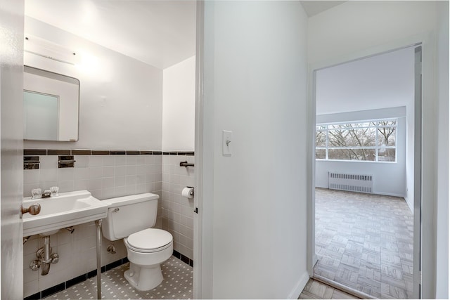 2727 Palisade Ave Unit 9-B, New York City, NY 10463 - bathroom featuring radiator heating unit, toilet, wainscoting, tile walls, and a sink