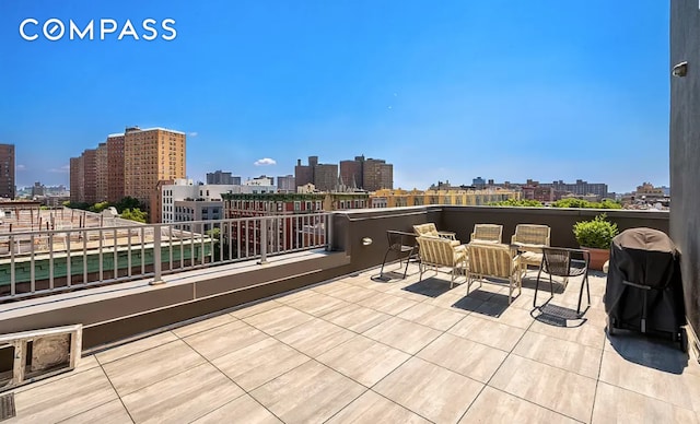 view of patio featuring grilling area, a balcony, and a city view