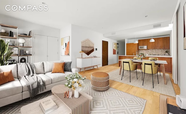 living room featuring light wood-style flooring and visible vents