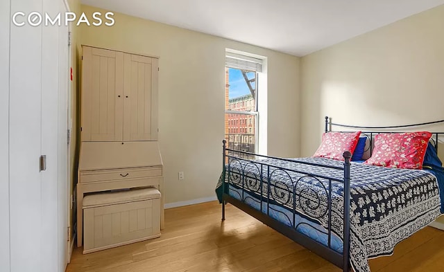 bedroom with baseboards and wood finished floors