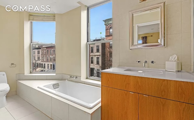 bathroom featuring toilet, tile walls, a bath, and tile patterned flooring