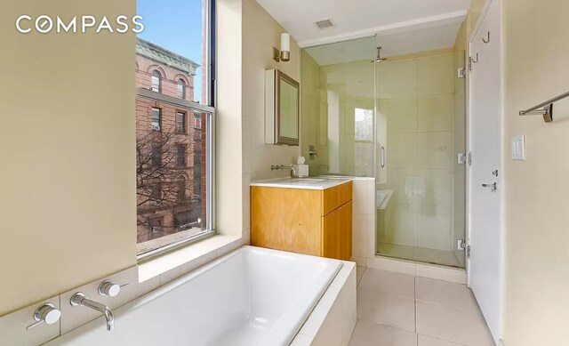 full bath featuring tile patterned flooring, visible vents, a shower stall, a bath, and vanity