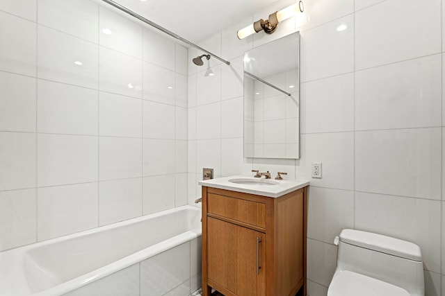 bathroom with tile walls, toilet, bathtub / shower combination, and vanity