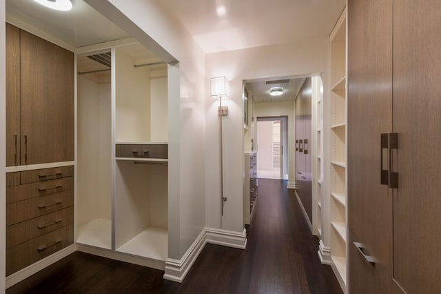 hall featuring visible vents, dark wood-style flooring, and baseboards