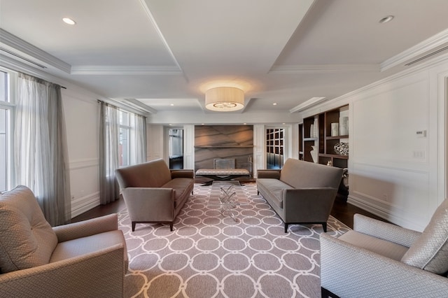 living area featuring crown molding, recessed lighting, a fireplace, wood finished floors, and a raised ceiling