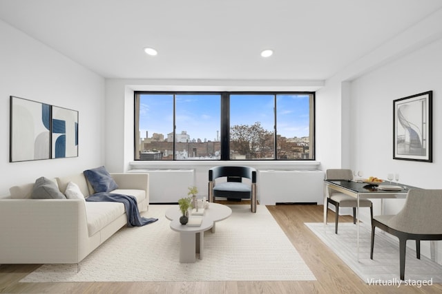 living area with recessed lighting, plenty of natural light, and wood finished floors