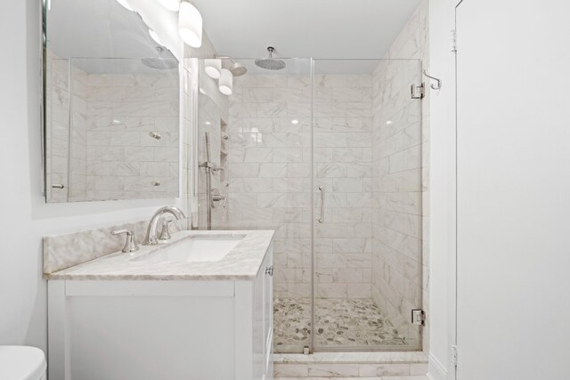 65 Cooper Sq Unit 6D, New York City, NY 10003 - bathroom featuring a stall shower, vanity, toilet, and marble finish flooring