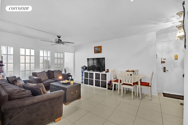 living area with light tile patterned floors, a ceiling fan, visible vents, and baseboards