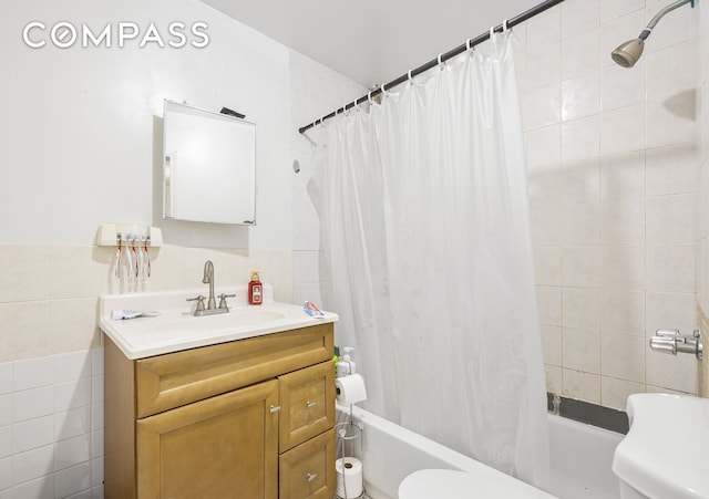 full bathroom with shower / bath combination with curtain, vanity, toilet, and tile walls