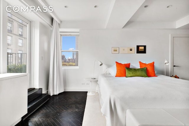 bedroom featuring a tray ceiling and baseboards