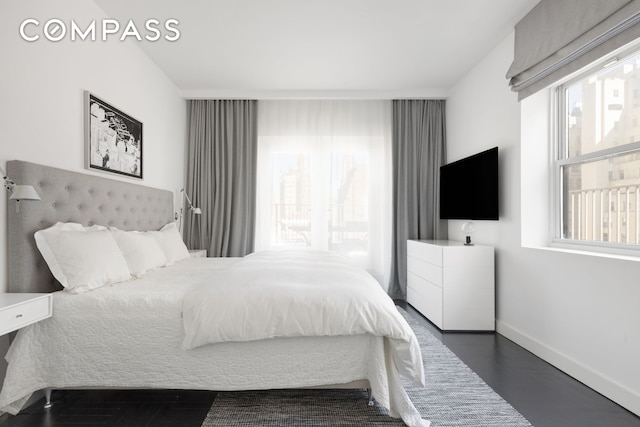 bedroom featuring dark wood-type flooring and baseboards