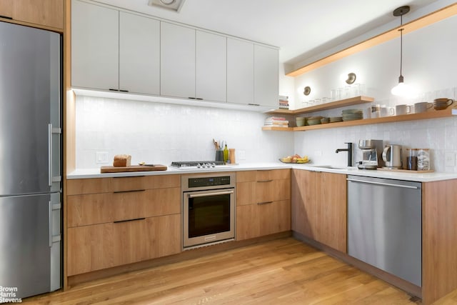 kitchen with stainless steel appliances, backsplash, and light countertops