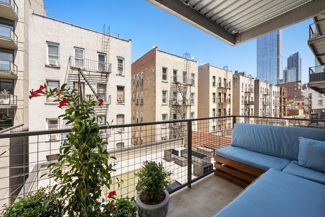 balcony featuring an outdoor living space, cooling unit, and a city view