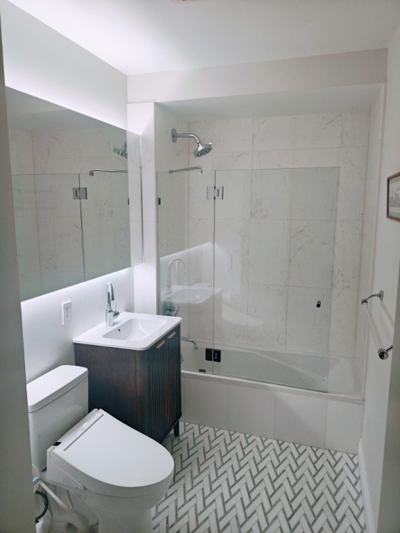 full bath with enclosed tub / shower combo, toilet, and vanity