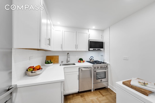 kitchen featuring a sink, decorative backsplash, white cabinets, and stainless steel appliances