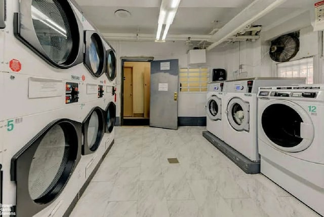 shared laundry area featuring stacked washer and dryer, marble finish floor, and washing machine and clothes dryer