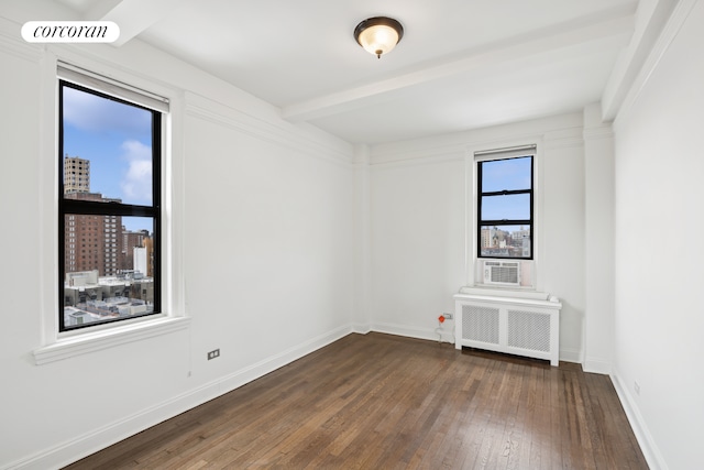 empty room featuring visible vents, baseboards, dark wood finished floors, and radiator heating unit