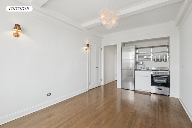 unfurnished living room with visible vents, beam ceiling, a notable chandelier, hardwood / wood-style flooring, and baseboards