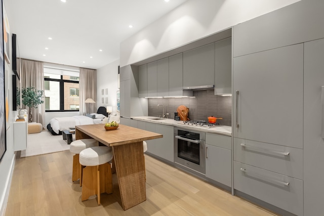 kitchen with a sink, modern cabinets, appliances with stainless steel finishes, and gray cabinetry