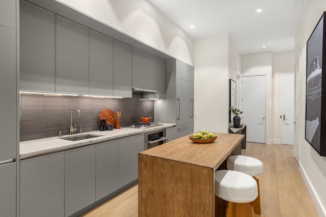 kitchen with gray cabinets, appliances with stainless steel finishes, and a sink